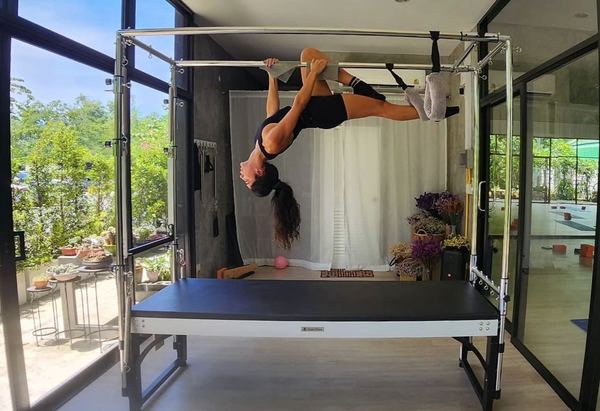 Yarden performing an inverted pose on the Cadillac apparatus