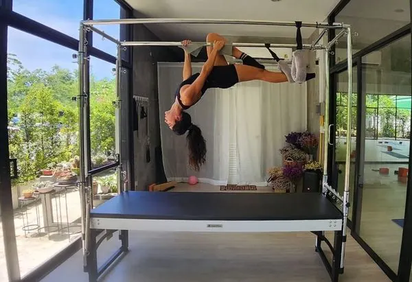 Yarden performing an inverted pose on the Cadillac apparatus
